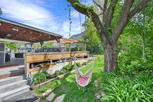 View of yard with a deck with mountain view and fence