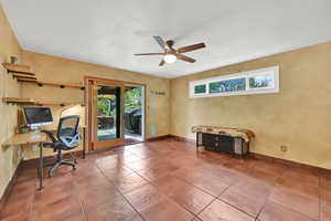 Office space featuring baseboards, tile patterned flooring, ceiling fan, and a textured ceiling