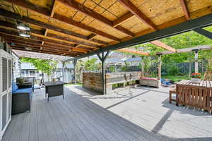 Wooden terrace featuring an outdoor hangout area and a fenced backyard