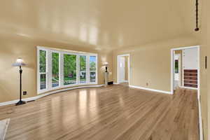Unfurnished living room with light wood-style flooring, baseboards, and visible vents