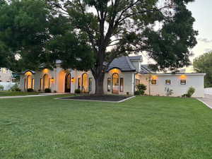 View of front of property with stucco siding and a front lawn