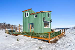 Snow covered property featuring board and batten siding