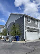 View of side of home with board and batten siding, a pergola, a garage, and driveway