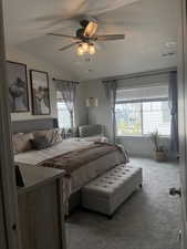 Carpeted bedroom with vaulted ceiling, a textured ceiling, visible vents, and ceiling fan
