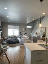 Living room featuring recessed lighting, a textured ceiling, wood-type flooring, and stairs