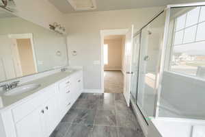 Full bath with a stall shower, double vanity, and a sink