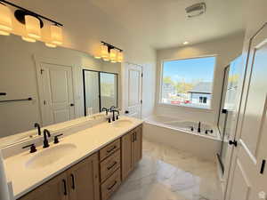 Bathroom featuring double vanity, a bath, and a sink