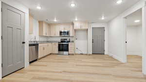 Kitchen featuring stainless steel appliances, light brown cabinets, baseboards, light wood-style floors, and recessed lighting