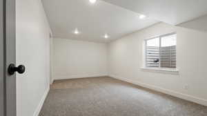 Carpeted spare room featuring baseboards and recessed lighting