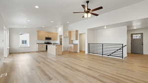 Unfurnished living room with light wood-type flooring, a wealth of natural light, and a sink