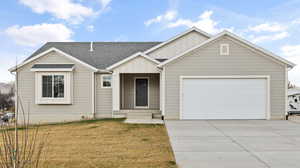 Single story home with roof with shingles, an attached garage, driveway, a front lawn, and board and batten siding