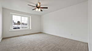 Empty room featuring baseboards, a ceiling fan, and carpet