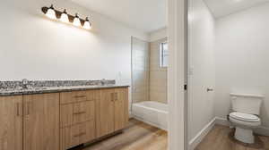 Full bath featuring toilet, wood finished floors, and a sink