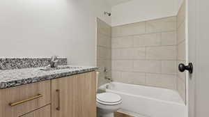 Full bath featuring vanity, toilet, and washtub / shower combination