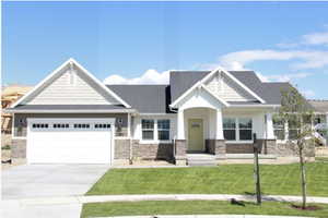 Craftsman inspired home featuring stone siding, board and batten siding, an attached garage, driveway, and a front yard