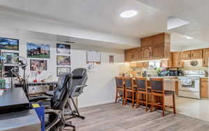 Office area with baseboards and light wood-style flooring