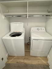 Laundry area featuring washer and dryer, laundry area, and wood finished floors