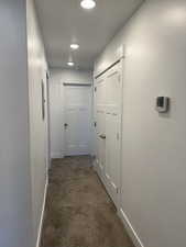 Hallway with carpet, baseboards, and recessed lighting
