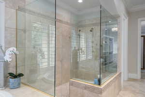 Bathroom with tile patterned flooring, ornamental molding, tiled shower, and recessed lighting