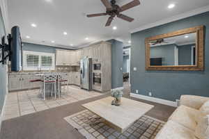 Nanny’s quarters or Family Apartment. Living area featuring recessed lighting, light tile patterned floors, ornamental molding, ceiling fan, and light carpet