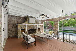 View of patio / terrace with an outdoor stone fireplace and ceiling fan