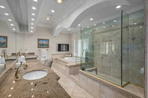 Bathroom featuring vanity, tile patterned floors, crown molding, a bath, and a tile shower