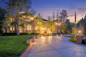 View of community with curved driveway and a lawn