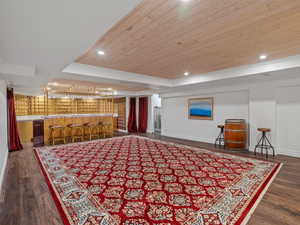 Interior space featuring wood ceiling, baseboards, dark wood-style floors, and bar area