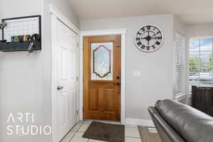 Entryway with baseboards and light tile patterned floors