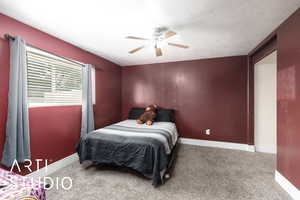 Bedroom featuring carpet, a textured ceiling, baseboards, and a ceiling fan