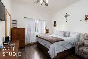Bedroom featuring a ceiling fan, wood finished floors, and vaulted ceiling