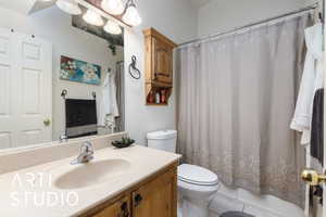 Bathroom featuring vanity, toilet, shower / bath combo, and tile patterned flooring