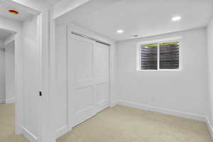 Unfurnished bedroom with baseboards and light carpet