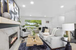 Living area with a high end fireplace and recessed lighting