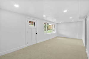 Entrance foyer featuring light colored carpet, baseboards, and recessed lighting