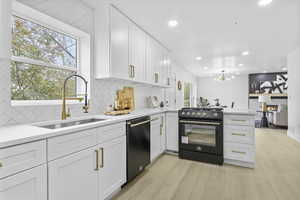 Kitchen with dishwasher, a sink, gas range, a peninsula, and backsplash