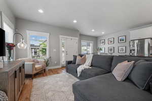 Living room featuring light wood-style floors, baseboards, and recessed lighting