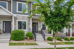 View of front of property with covered porch and stone siding