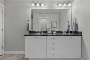 Bathroom with baseboards, double vanity, and a sink