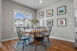 Dining area with baseboards, plenty of natural light, and wood finished floors