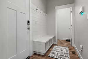 Mudroom with baseboards, visible vents, and wood finished floors