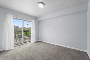 Empty room featuring carpet and baseboards