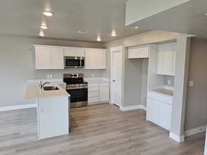 Kitchen with stainless steel appliances, baseboards, and a sink