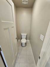 Bathroom featuring toilet, visible vents, baseboards, and tile patterned flooring
