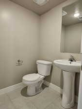 Half bathroom featuring toilet, visible vents, baseboards, and a textured ceiling
