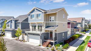 View of front of home with a residential view, an attached garage, and a balcony