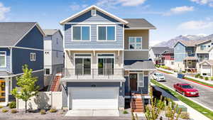 View of front of home with driveway, a residential view, fence, a mountain view, and an attached garage