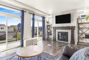 Living room featuring recessed lighting, a glass covered fireplace, and wood finished floors