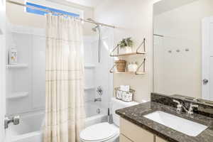 Full bathroom with vanity, toilet, and shower / bath combination with curtain