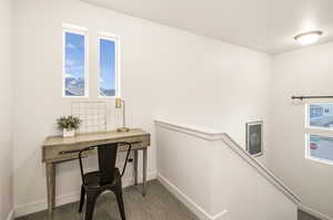 Carpeted office space with baseboards